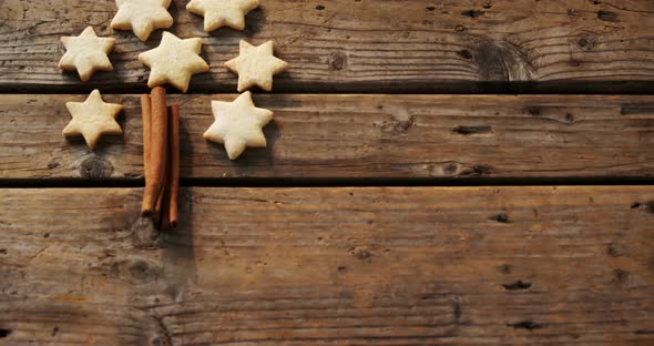 Christmas cookies and cinnamon sticks on wooden table 4k