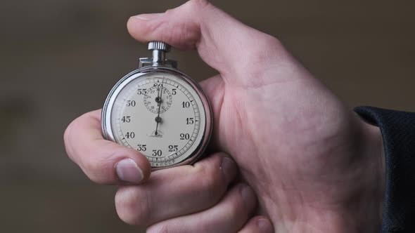 Stopwatch in Male Hand Counts Down Seconds