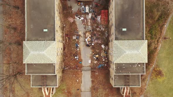 a top down shot directly over an abandoned building. The drone camera pedestal downward & descends o