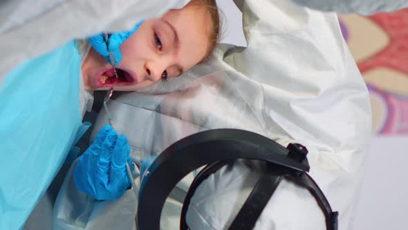 Vertical Video Close Up of Dentist in Coverall Examining Girl Patient in New Normal Dental Unit