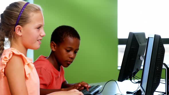 School kids using computer in classroom