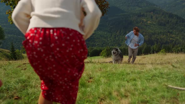 Happy Family Loving Husky Spending Vacation in Mountain