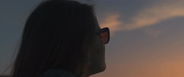 A woman looking at sky at sunset