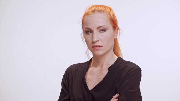 Middleaged Caucasian Female with Colored Orange Hair and Dark Brown Shirt Standing on White