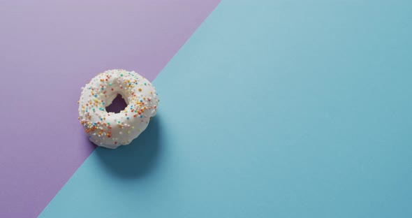 Video of donut with icing on purple and blue background