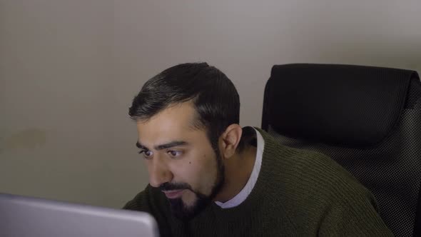 Man looks at computer and is happy