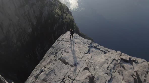 Woman standing on the edge of Preikestolen (Pulpit Rock), Norway