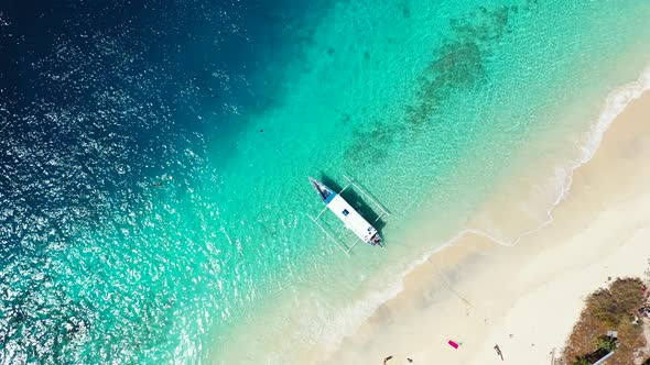 Beautiful drone travel shot of a sunshine white sandy paradise beach and turquoise sea background 