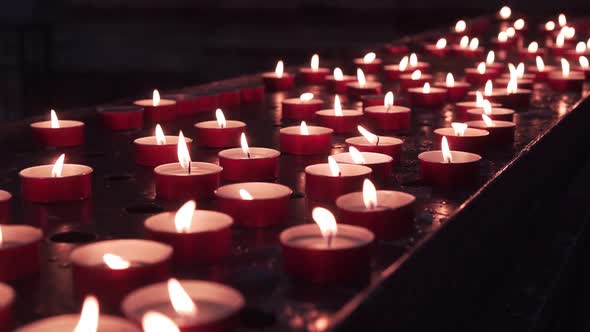 Many Candles Lit on a Metal Surface