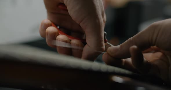 Guitar Tech Cuts the Strings on the Guitar By Nippers in Slow Motion Changing the Strings on the