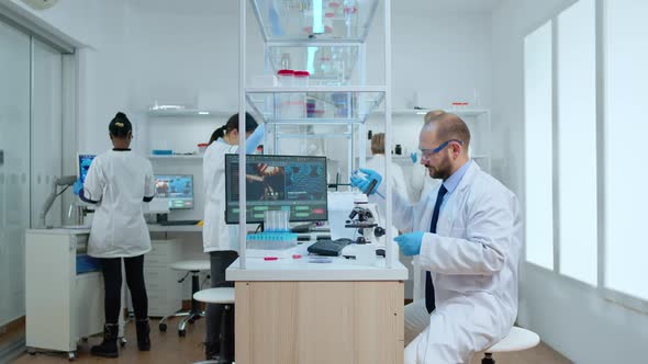 Man Scientist Positioning Petri Dish Under Microscope in Laboratory alt