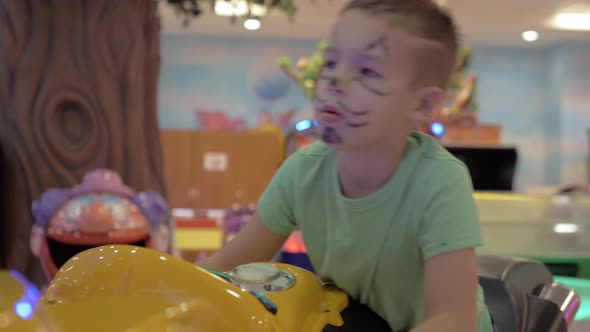 Child is attracted with racing simulator in amusement park