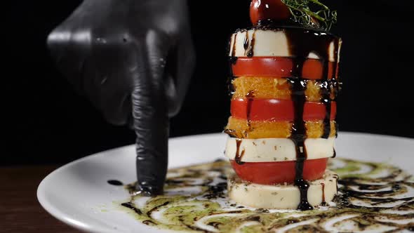 Slow Motion Food Video Concept. Salad Caprese on White Plate Poured with Balsamic Reduction. Sliced