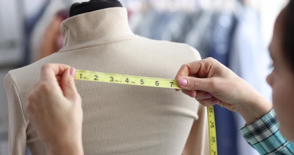 Female Tailor Takes Measurements on Mannequin Closeup