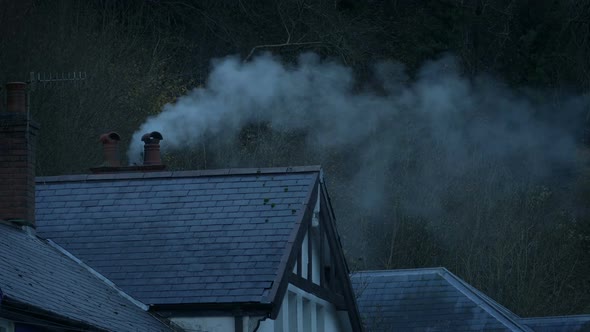 Home With Smoking Chimney On Winter Evening