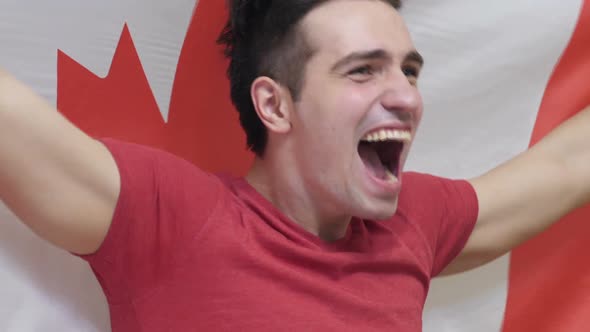 Canadian Young Man Celebrating While Holding the Flag of Canada in Slow Motion