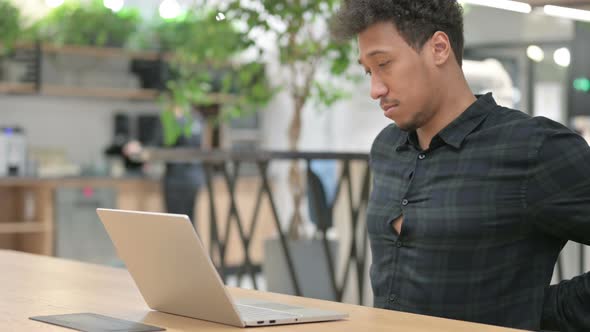 African American Man with Laptop Having Back Pain