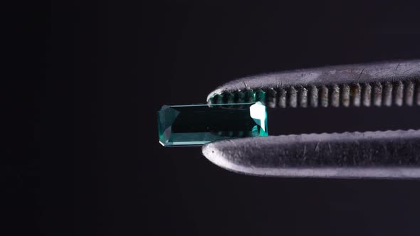 Natural Blue Grandidierite Gemstone in the Tweezer on the Turn Table