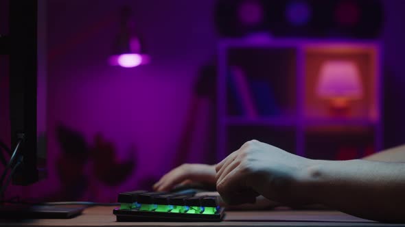 Gamer Typing on Backlight Keyboard Closeup Man Playing Video Game