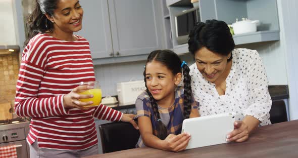 Multi-generation family using digital tablet in kitchen 4k