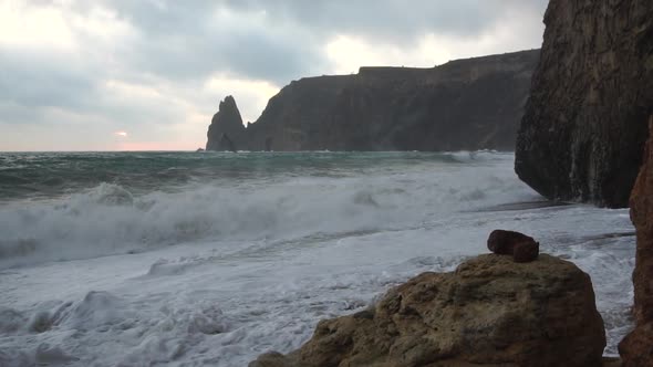 A Red Burning Sunset Over the Sea with Rocky Volcanic Basalt Cliff