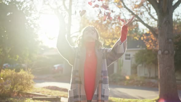 Smiling Happy Woman Throwing Dry Red Maple Leaves Up in the Air Autumn Foliage