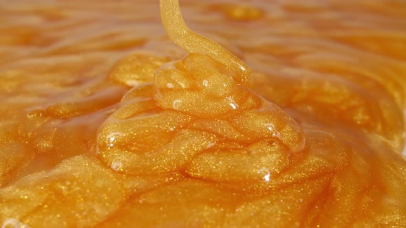 Slow Motion Shot of Pouring Oil Liquid Yellow Golden Hue