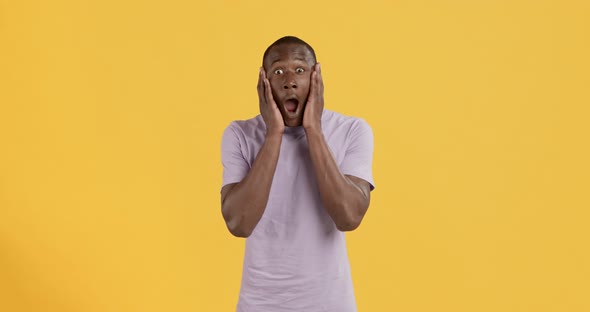 Shocked Black Man Touching Cheeks, Feeling Amazement