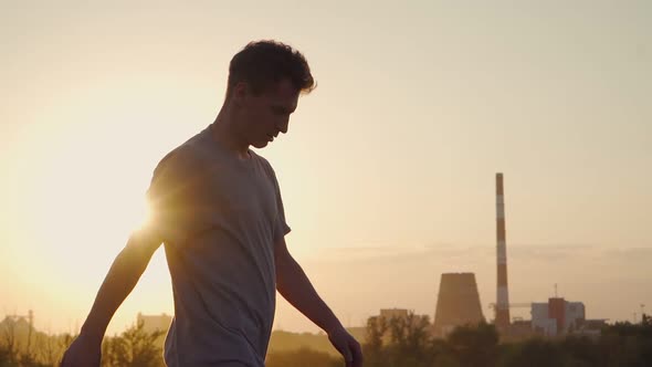 A cool man walks against the backdrop of a beautiful sunset. Slow motion