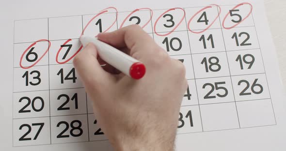 Man's Hand Write Down the 6789101112Th Day on Calendar Using a Red Pen