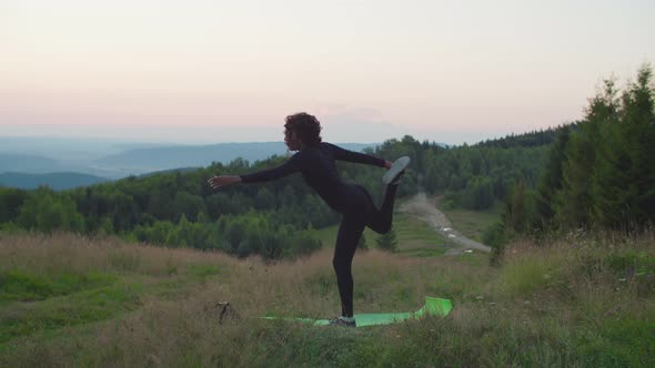 Elegant Flexible Sporty Fit African Woman Standing in Dancer Yoga Pose in Mountains at Daybreak