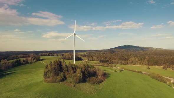 Slow motion shot of wind turbine on a green hill in the mountains