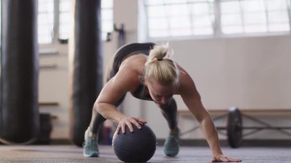 Fit caucasian woman working out with medicine ball at the gym