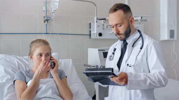 Male Doctor Visiting Female Patient in Hospital Ward