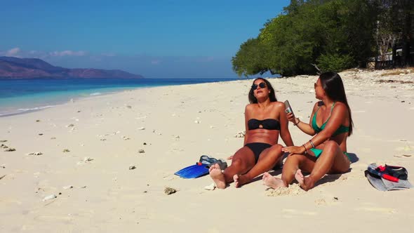 Ladies together enjoying life on relaxing bay beach holiday by transparent sea with white sand backg