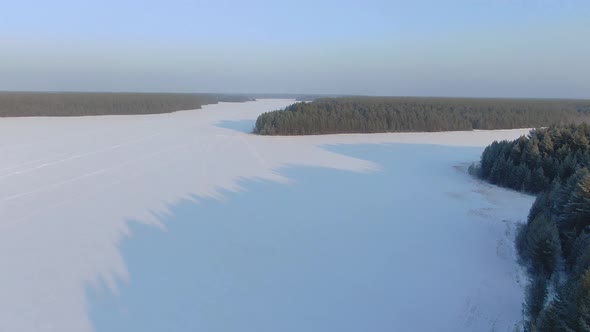 Flight Over a Taiga Forest Lake in Winter