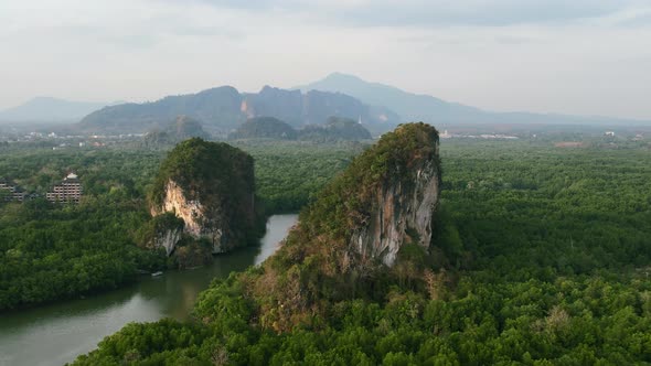 aerial drone panning shot of large green limestone mountain rocks (Khao Khanap Nam) with a mangrove