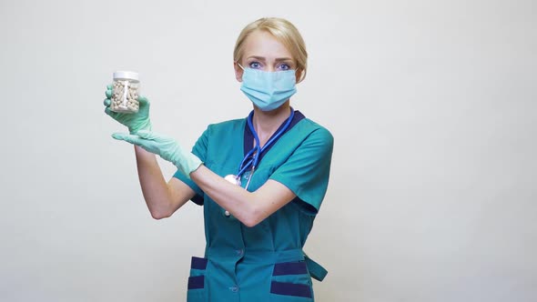 Medical Doctor Nurse Woman Wearing Protective Mask and Rubber or Latex Gloves - Holding Pills
