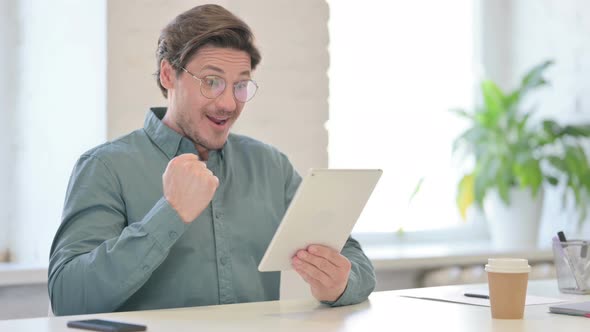 Successful Middle Aged Man Celebrating on Tablet 