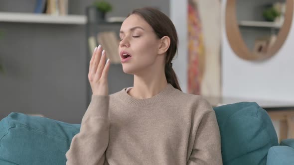 Portrait of Woman Yawning on Sofa