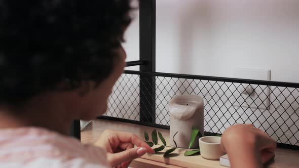 Woman with Matchsticks Lighting Candles at Home