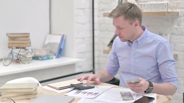 Businessman Counting Currency and Calculating