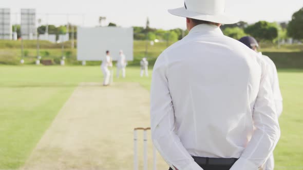 Rear view of cricket payer throwing a ball