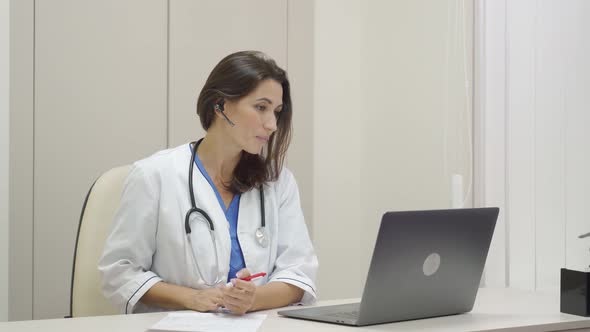 Hispanic Female Doctor Wear Headset Make Online Video Call Consult Patient