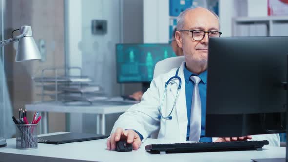 Elderly Doctor Working on PC