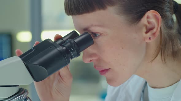 Female Scientist Doing Lab Research with Microscope