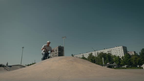 BMX Cyclist Extreme in the City Park Performs Dangerous Jumping Stunts