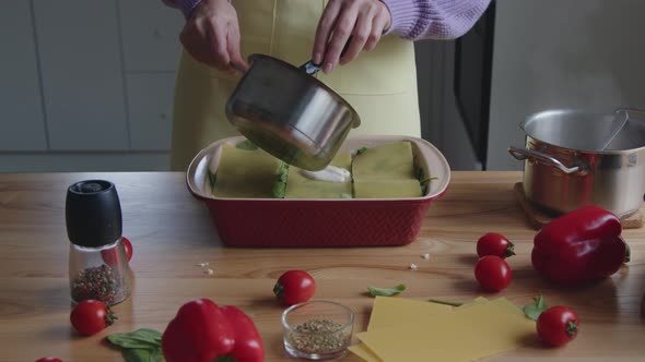 Woman Is Adding White Sauce to Pasta