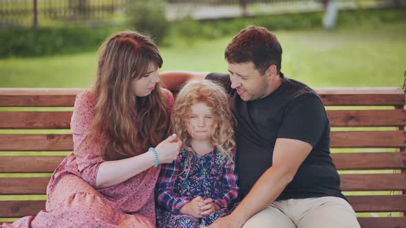 A Young Family on a Swing in the Garden