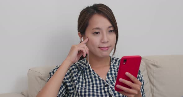 Woman Watch on Phone with Earphone at Home